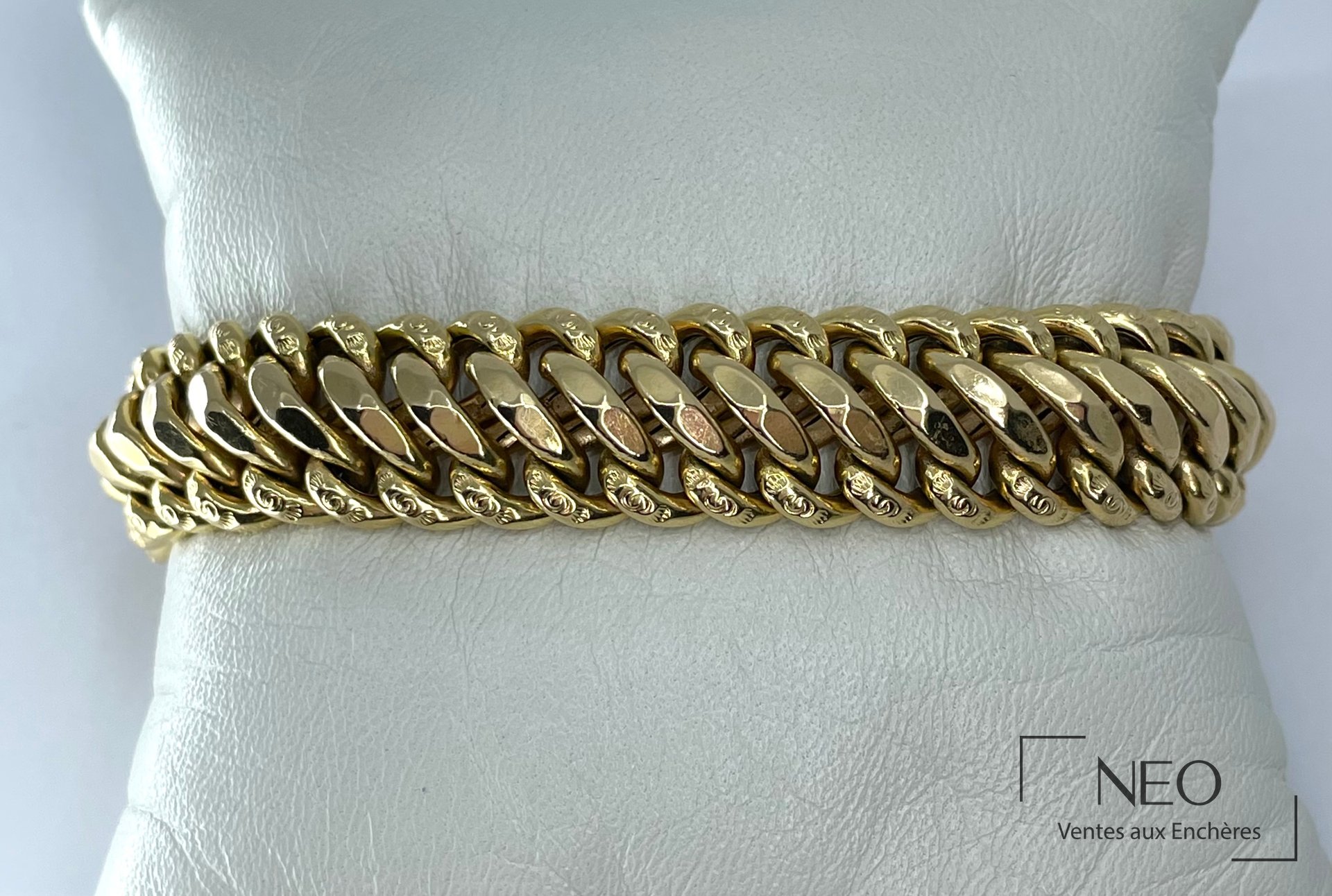 Bracelet maille souple en or jaune présenté de face sur support blanc