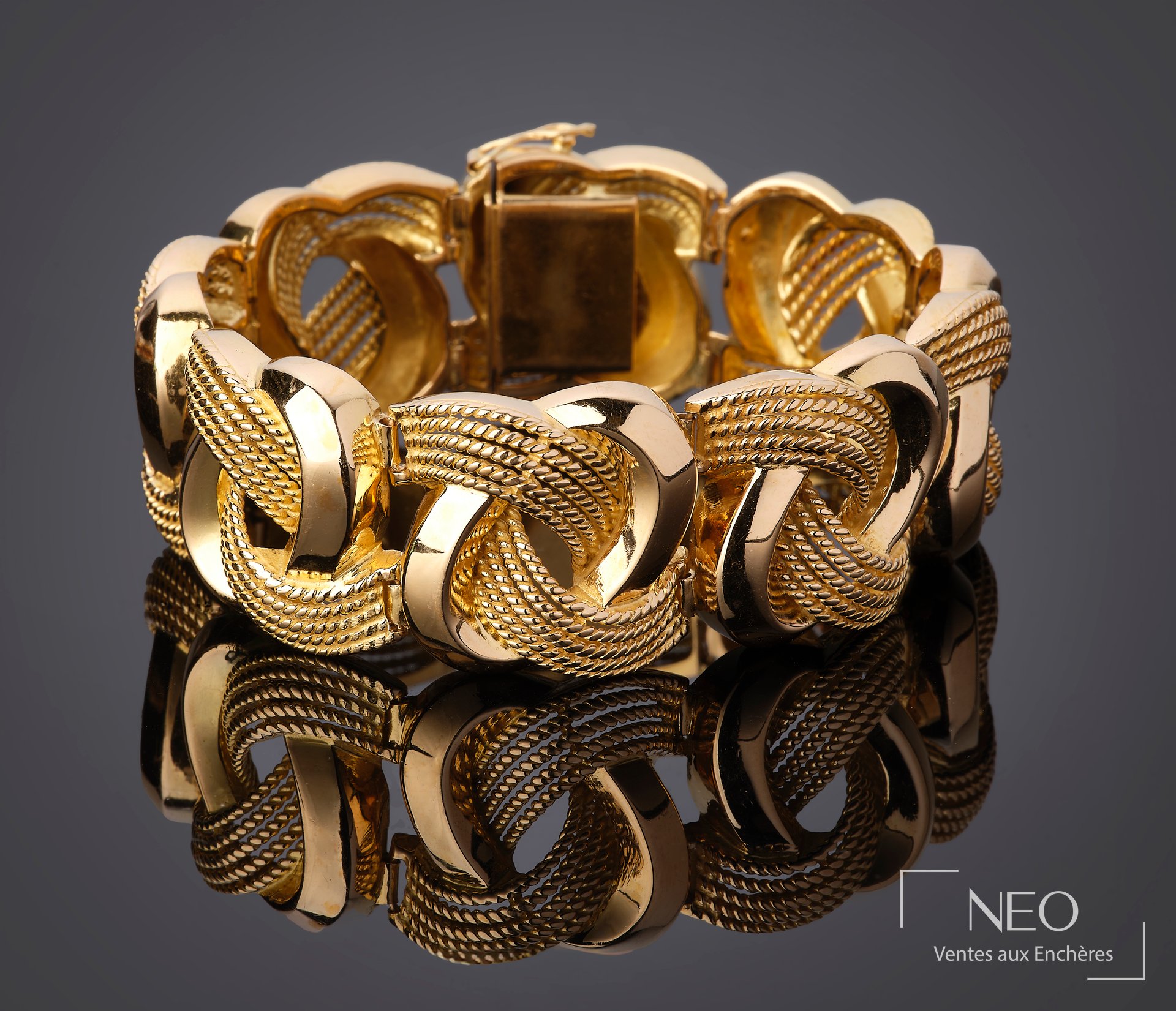 Bracelet manchette en or jaune aux motifs d’ovales biseautés et fils torsadés