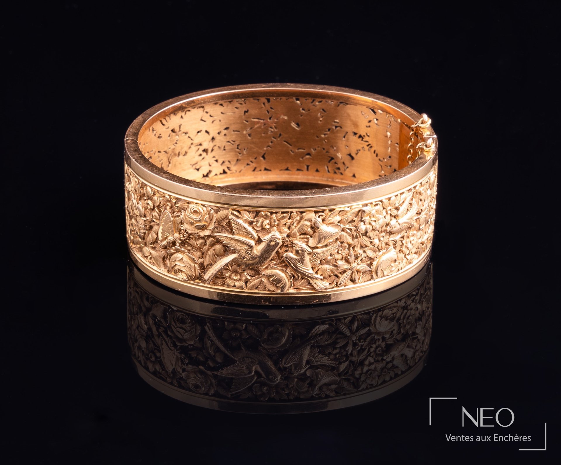 Bracelet manchette ouvrant en or rose à décor ajouré de fleurs et d'oiseaux