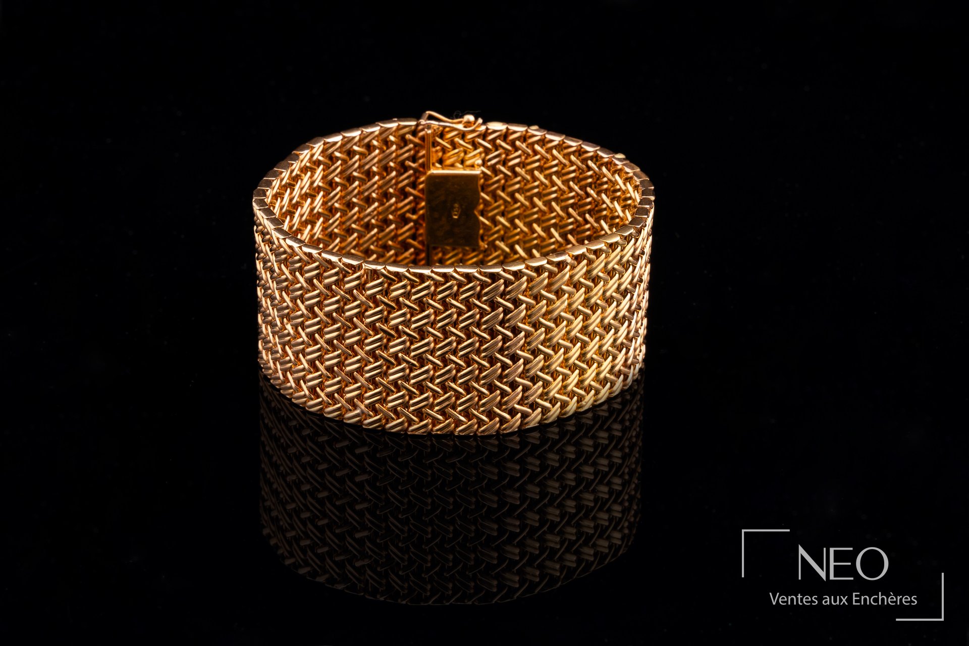 Bracelet en or jaune à mailles torsadées présenté fermé sur fond noir