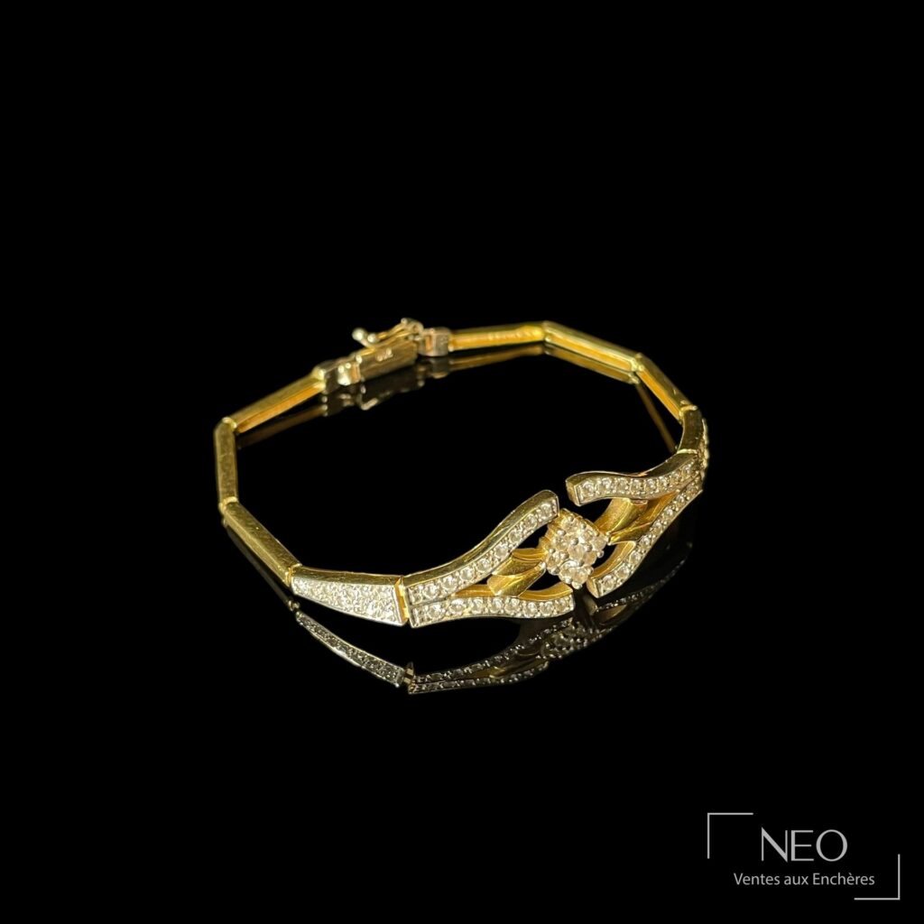 Bracelet en or jaune avec motif central serti de pierres blanches sur fond noir
