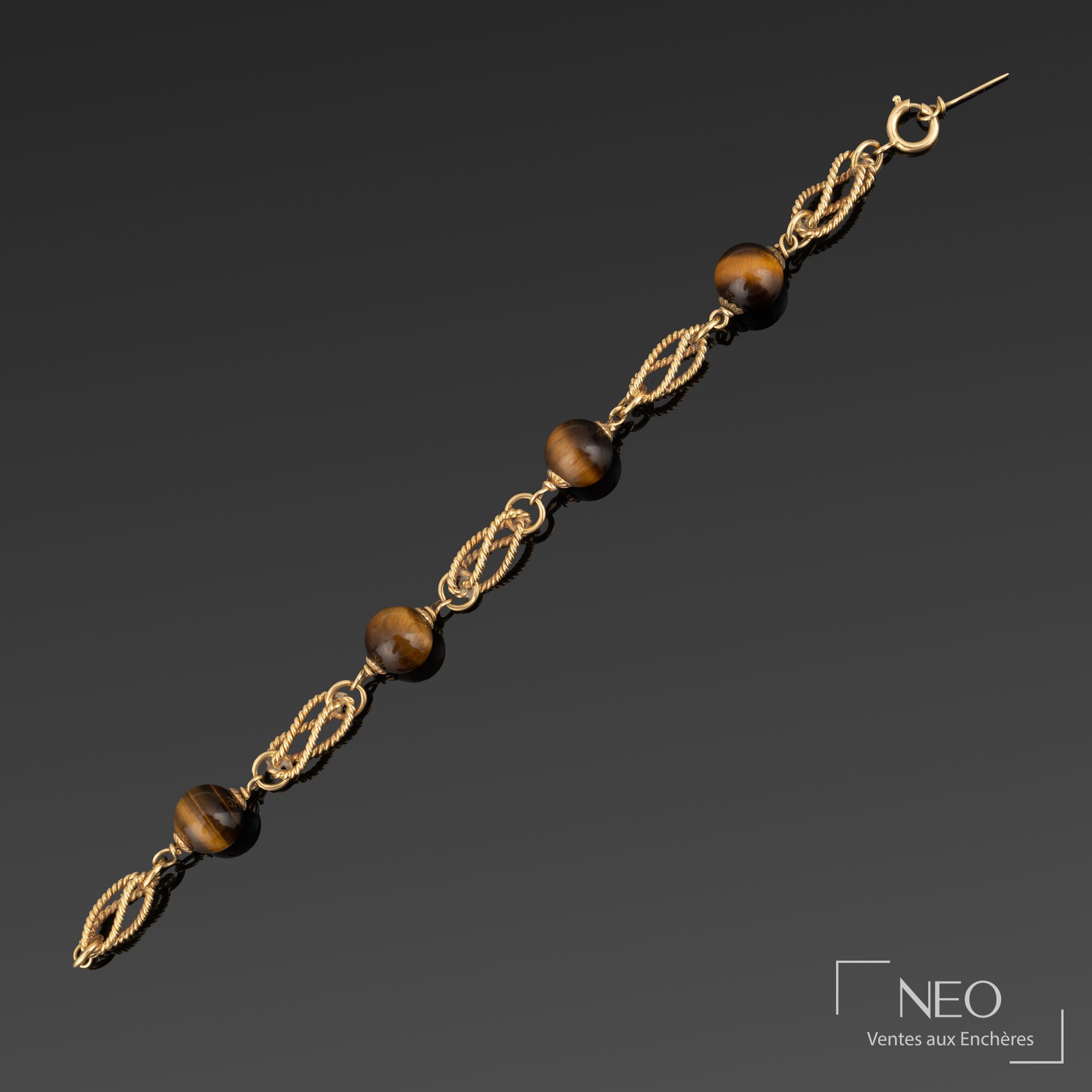 Bracelet en or jaune à perles d’œil de tigre sur fond sombre