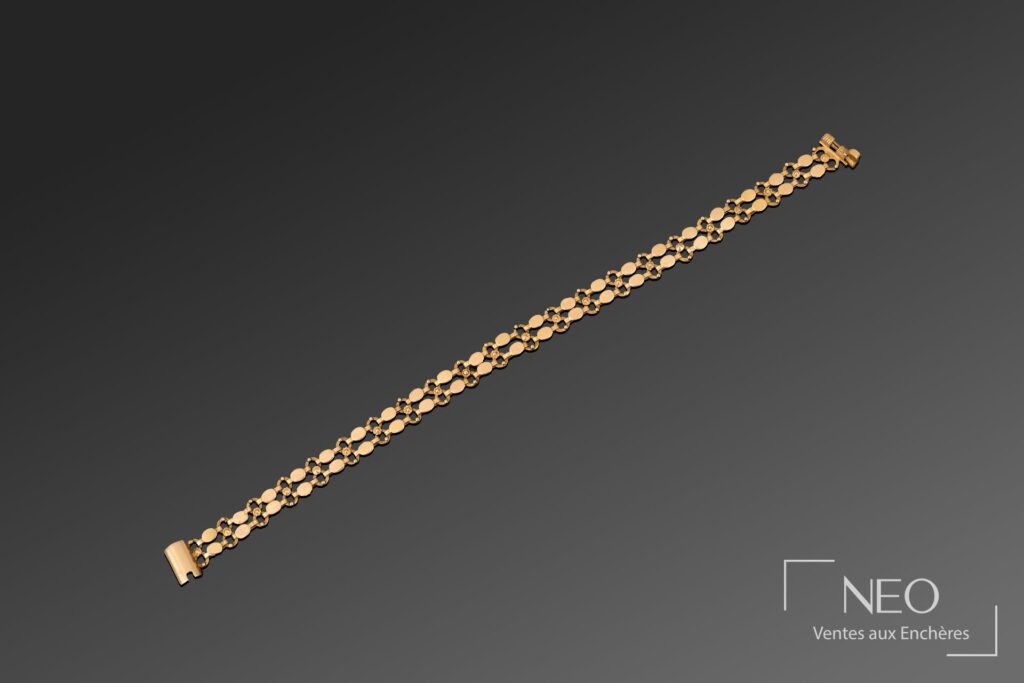 Bracelet en or jaune à mailles fantaisie sur fond gris