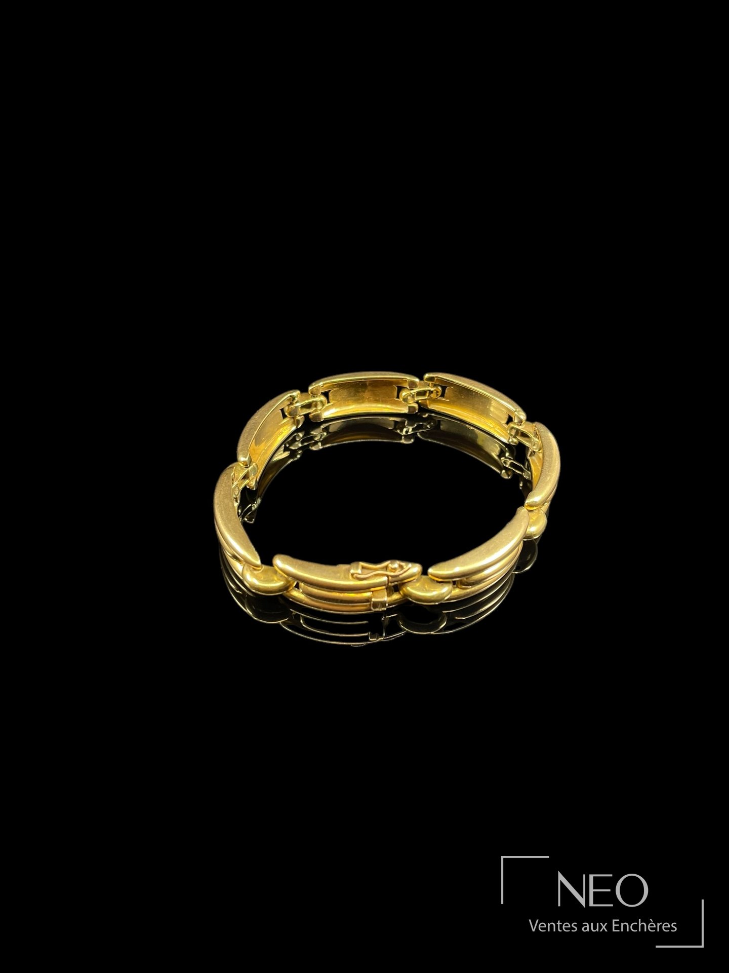 Bracelet en or jaune articulé vu de face sur fond noir