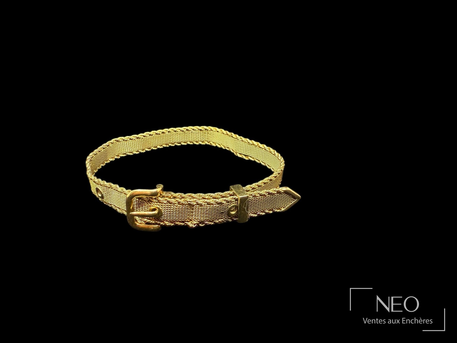 Bracelet en or jaune en forme de ceinture à boucle sur fond noir