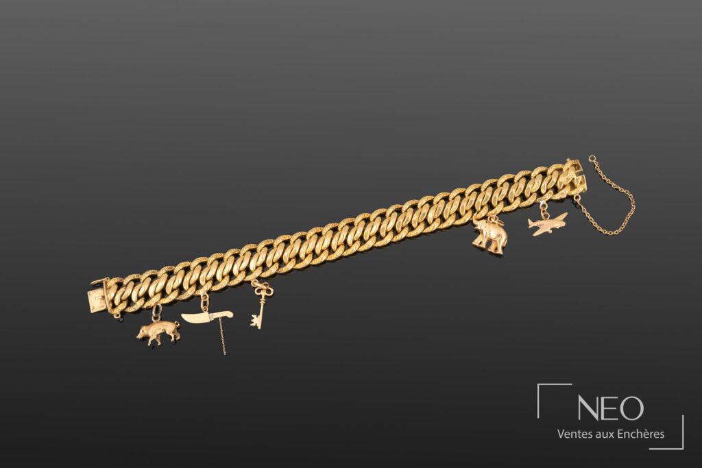 Bracelet en or jaune à mailles américaines avec plusieurs charms figuratifs