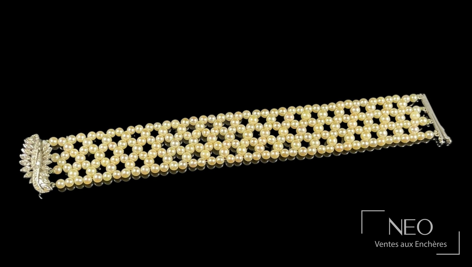 Bracelet ruban en or gris et perles de culture présenté de face sur fond noir