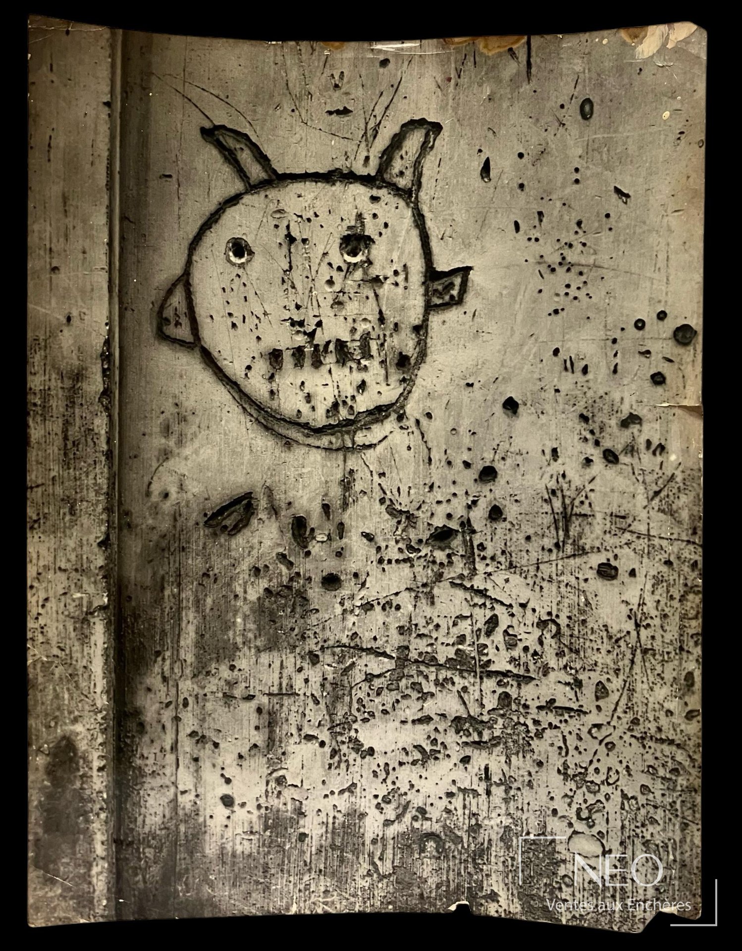 Photographie de Brassaï montrant un graffiti avec visage stylisé sur fond de mur