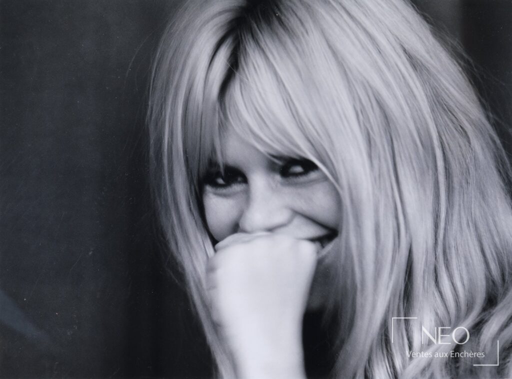 Portrait monochrome de Brigitte Bardot avec mèche blonde et sourire discret