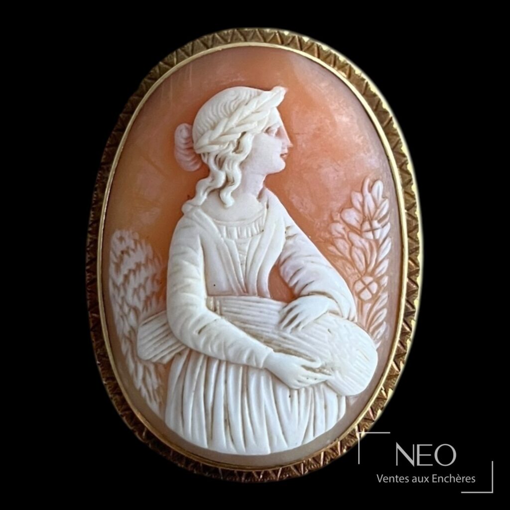 Broche ovale en or jaune avec camée coquille représentant une femme à la moisson