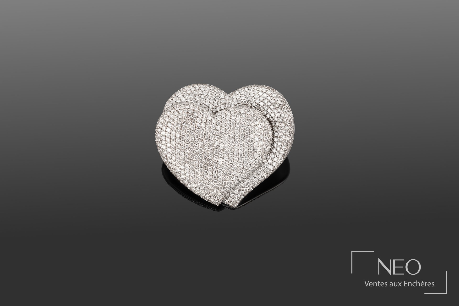 Broche en forme de deux cœurs pavée de diamants sur fond gris