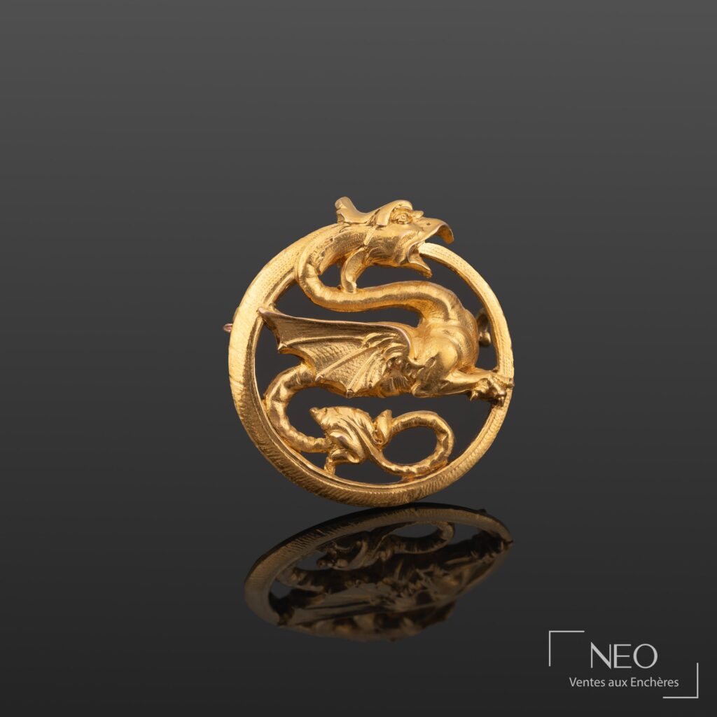 Broche ronde en or jaune à décor ajouré d'un dragon stylisé