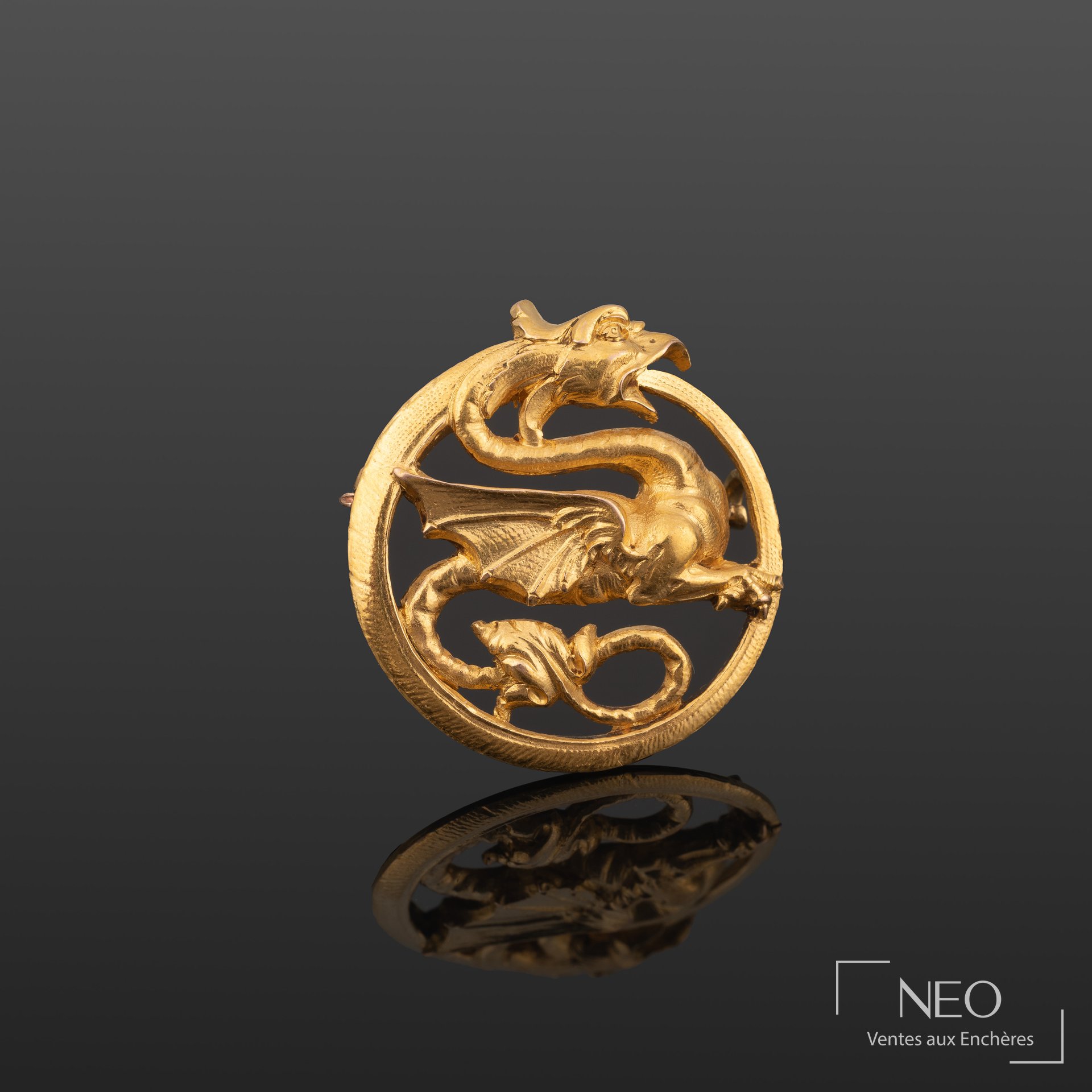 Broche ronde en or jaune à décor ajouré d'un dragon stylisé