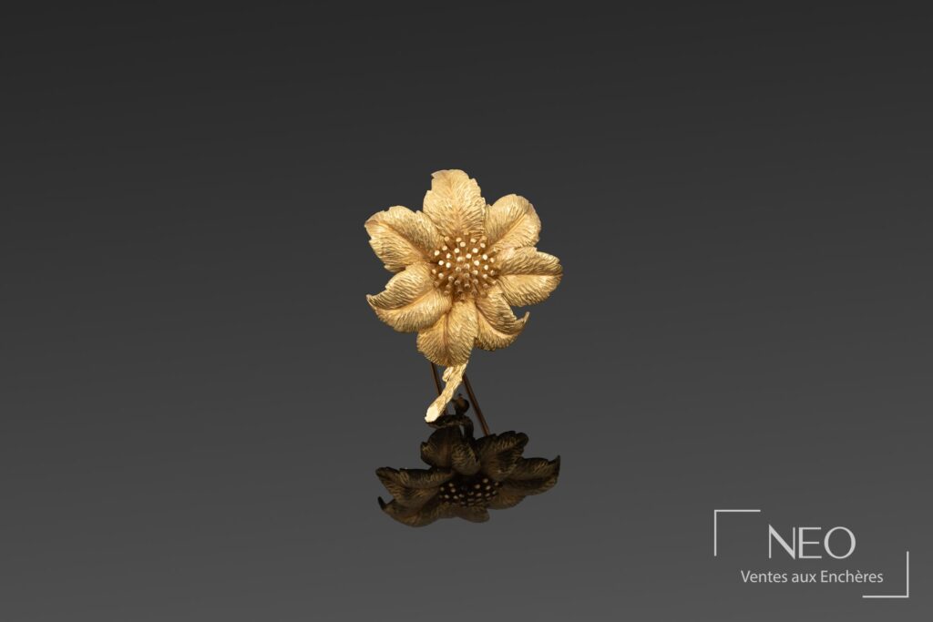 Broche en forme de fleur en or jaune et or rose sur fond gris