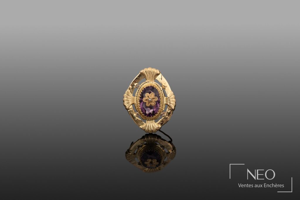 Broche ajourée en or jaune avec pierre violette centrale