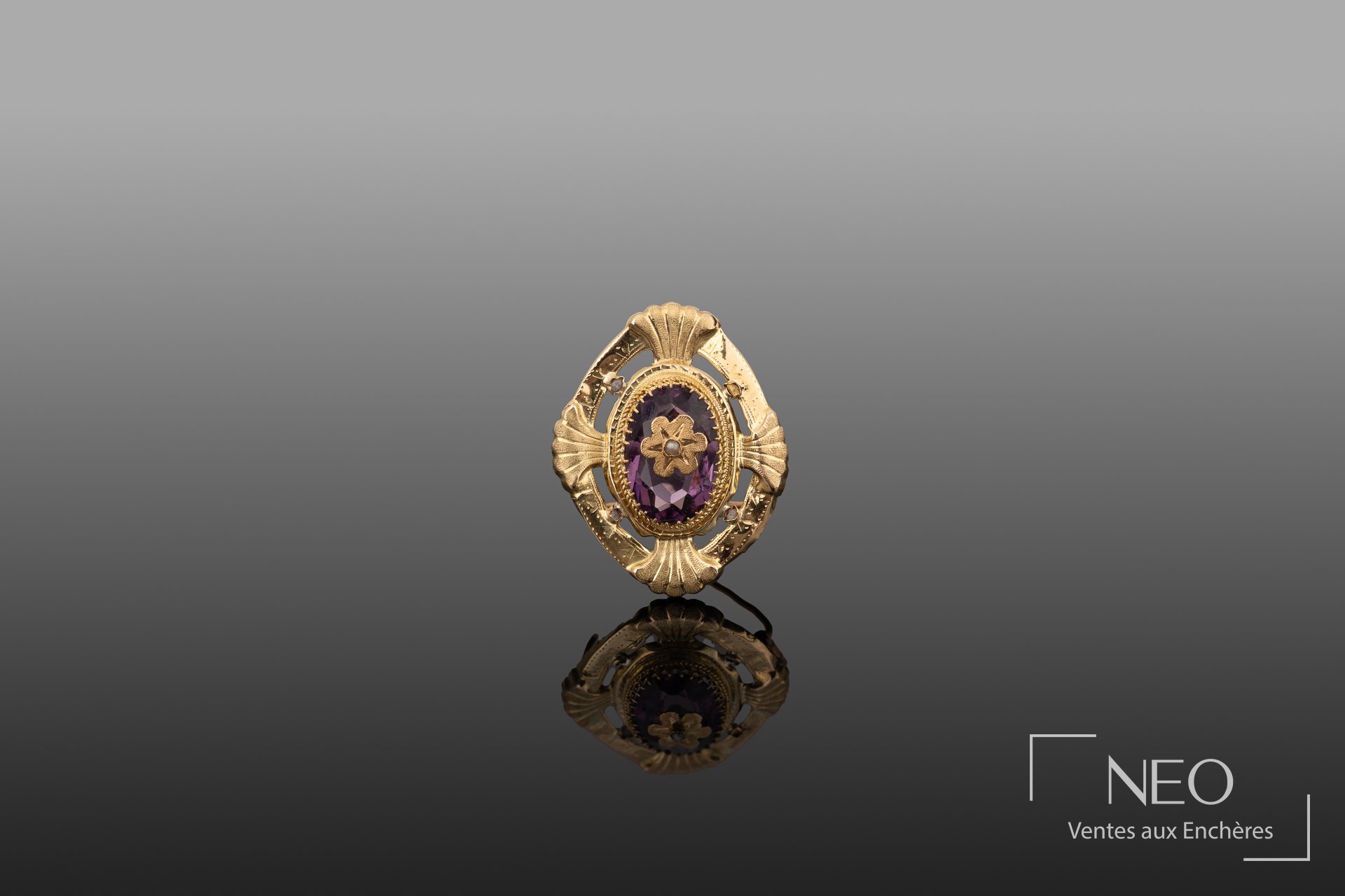 Broche ajourée en or jaune avec pierre violette centrale