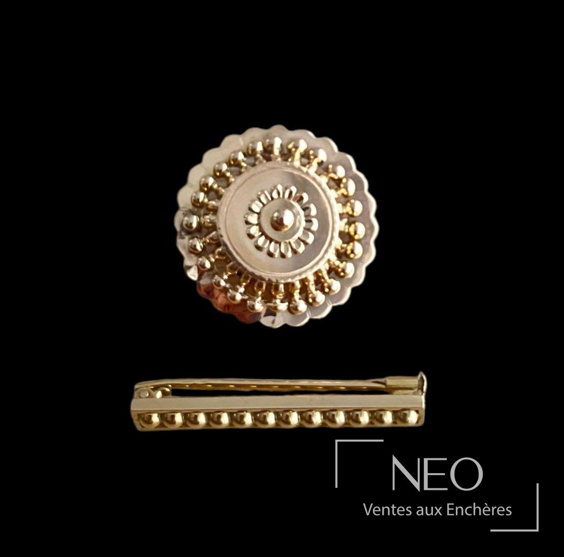 Broche circulaire et broche barette en or jaune et or rose sur fond noir