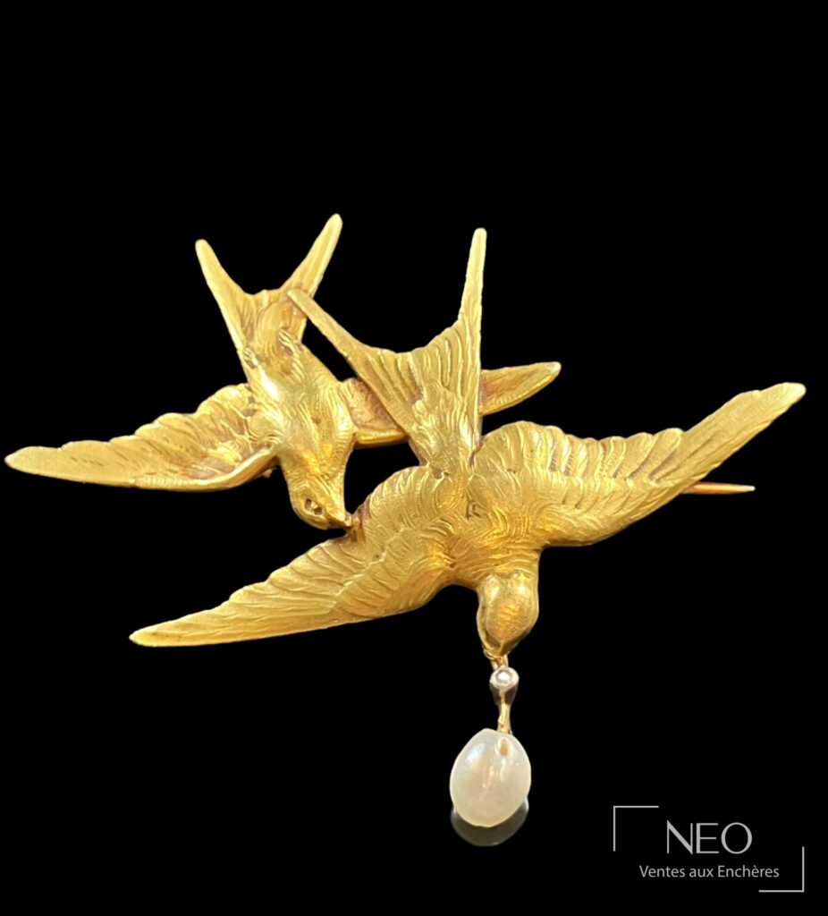 Broche en or jaune en forme de deux hirondelles avec perle baroque pendante
