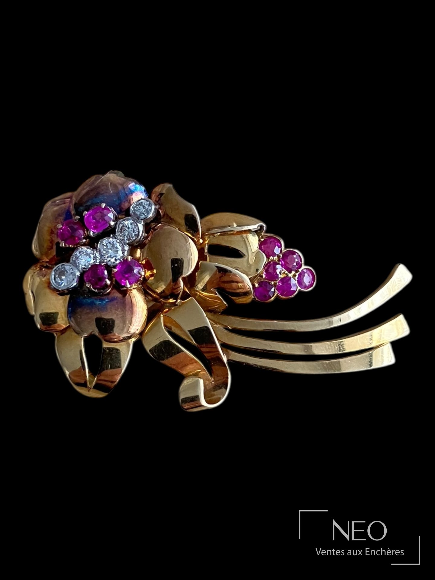 Broche florale en or jaune et platine ornée de diamants et rubis sur fond noir
