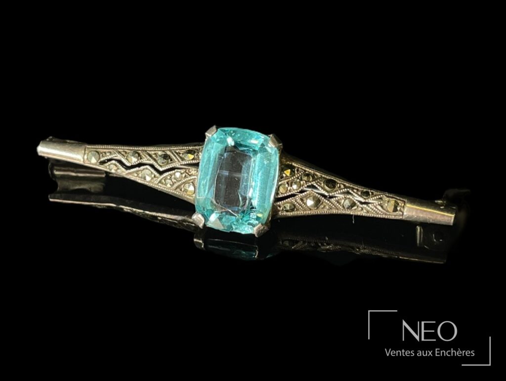 Broche losange en argent avec pierre bleue centrale sur fond noir