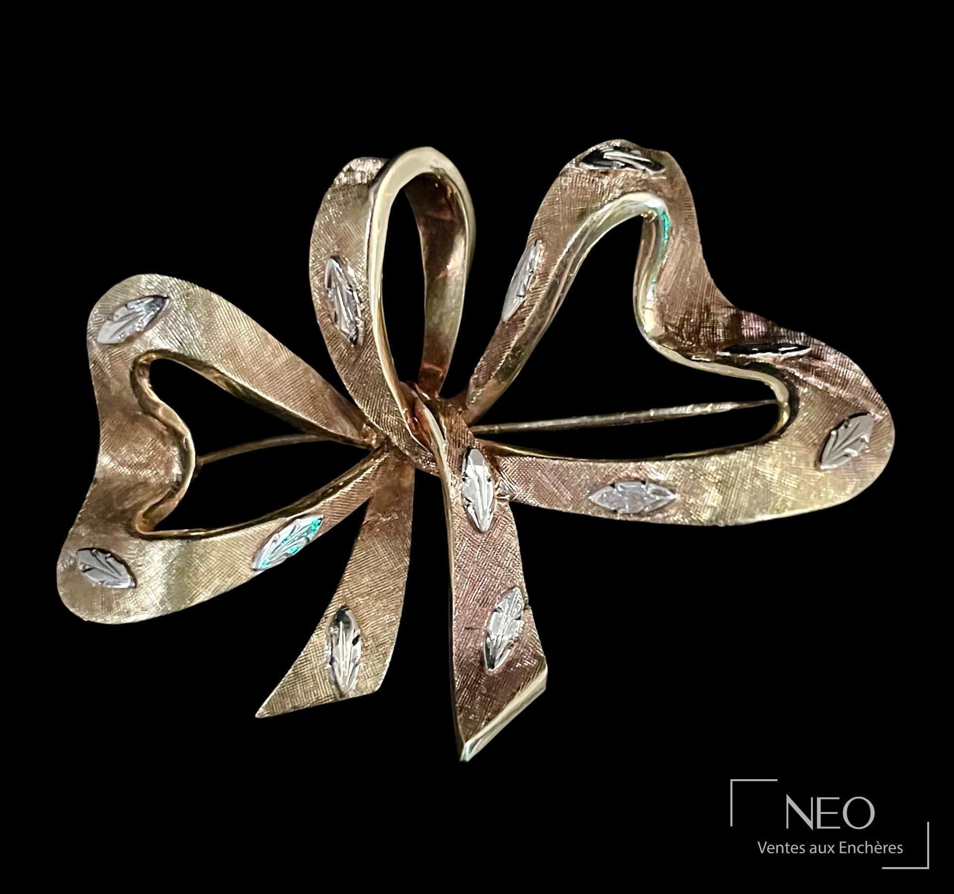 Broche nœud en or jaune et gris 18 carats à fond résillé