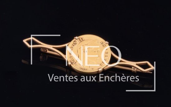 Broche en or jaune 18 carats enserrant une pièce de 10 francs or