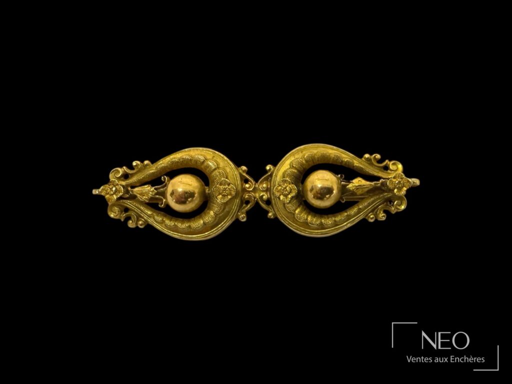 Broche en or jaune 18K à décor symétrique avec éléments floraux et boules centrales