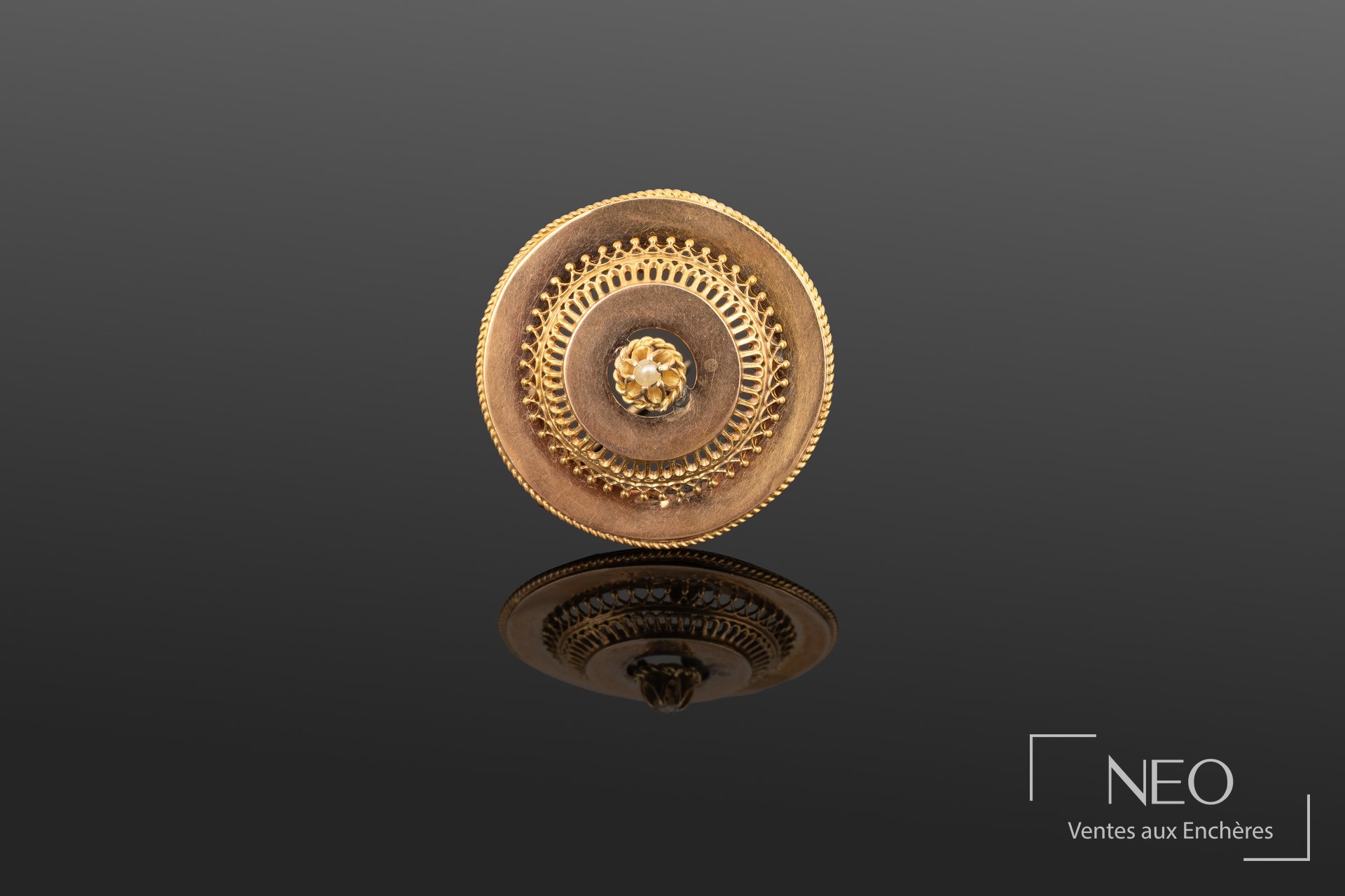 Broche circulaire en or jaune ajouré avec semence de perle blanche