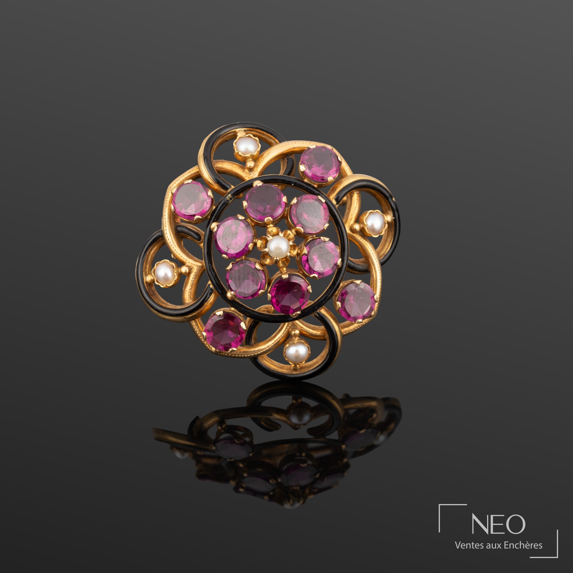 Broche ajourée en or jaune sertie de pierres violettes et de perles blanches