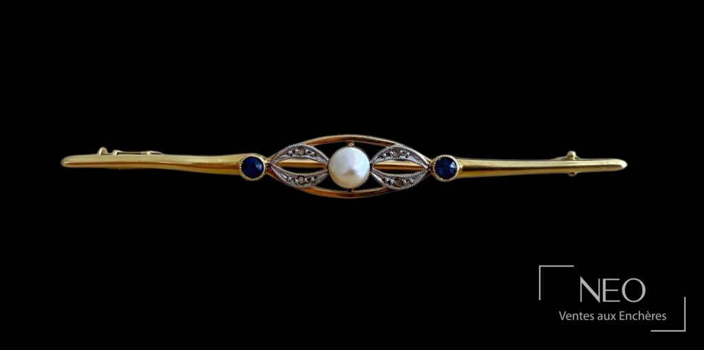 Broche en or jaune et gris avec perle fantaisie blanche et deux pierres bleues