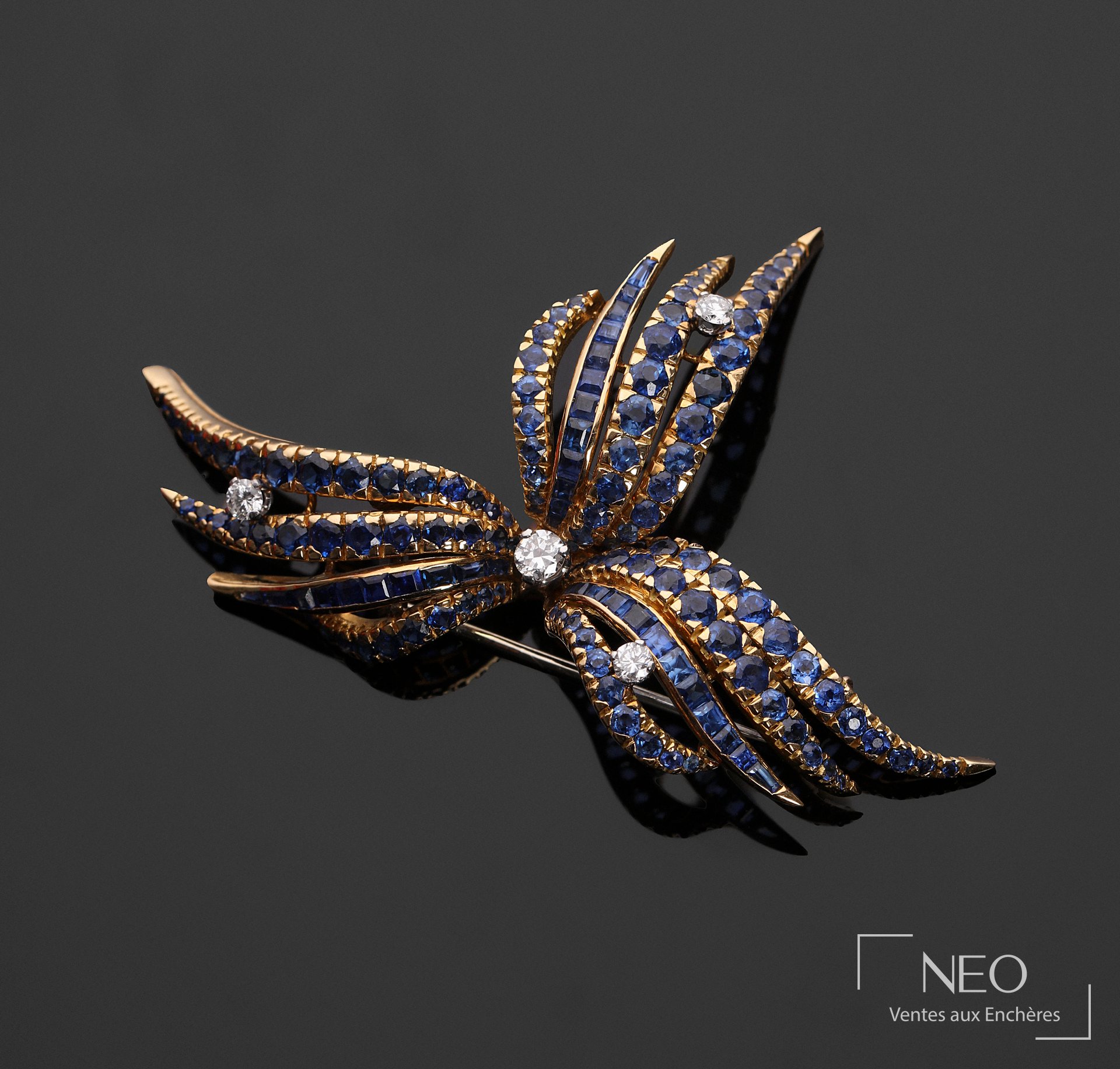 Broche en or jaune et gris sertie de saphirs et de quatre diamants