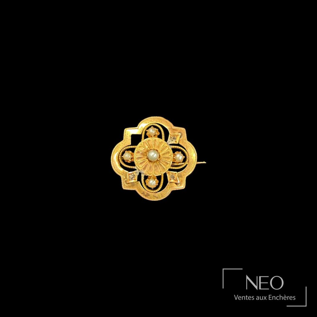Broche polylobée en or rose avec perles blanches et petites pierres blanches sur fond noir