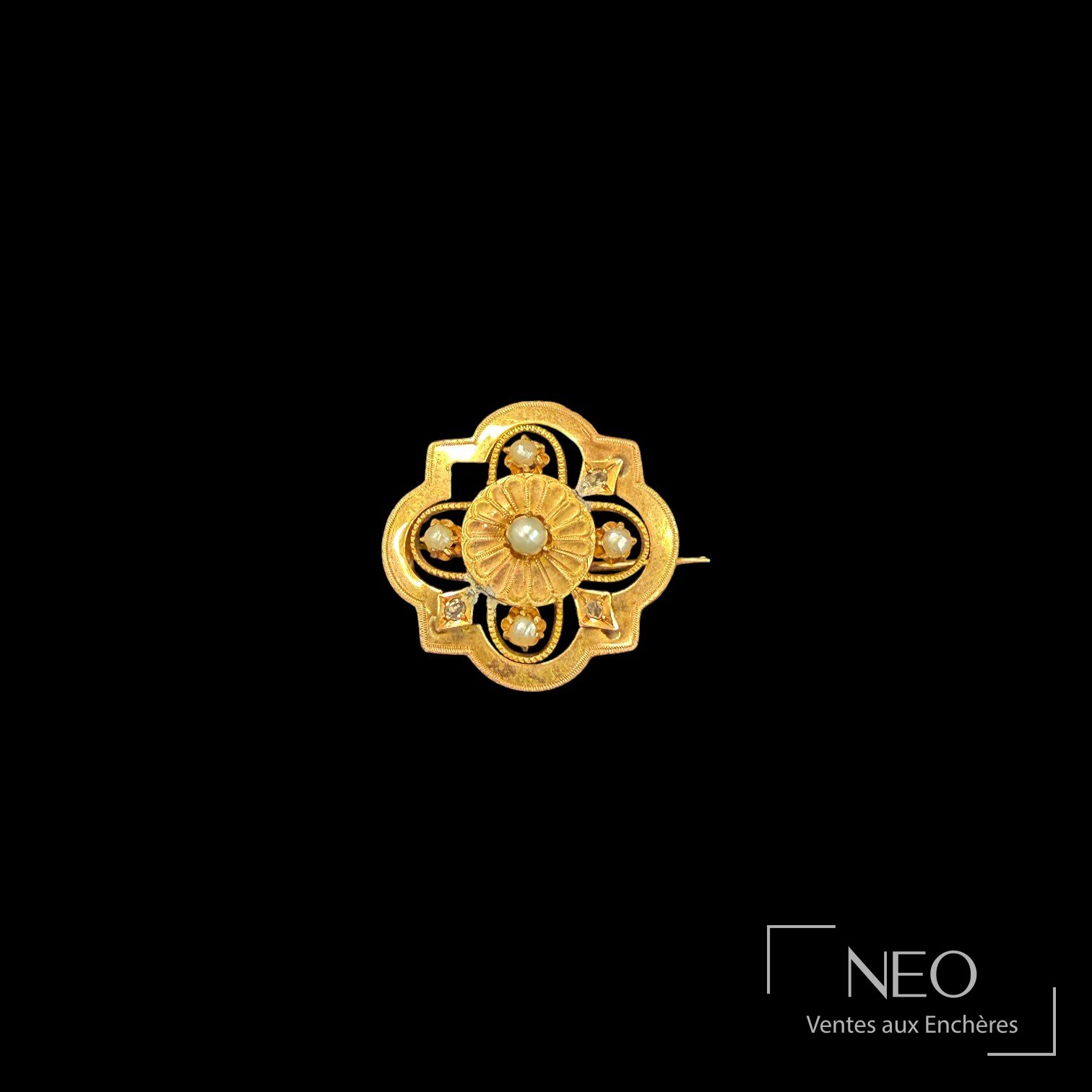 Broche polylobée en or rose avec perles blanches et petites pierres blanches sur fond noir