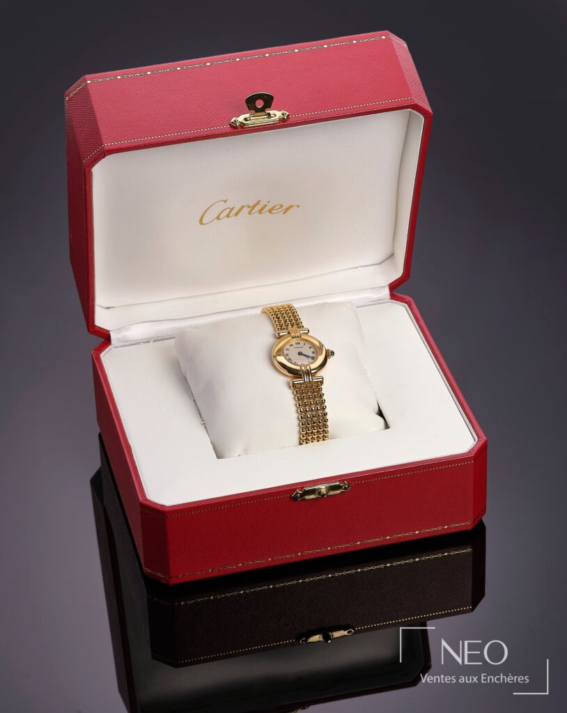 Montre Cartier Colisée en or jaune présentée dans son écrin rouge et blanc