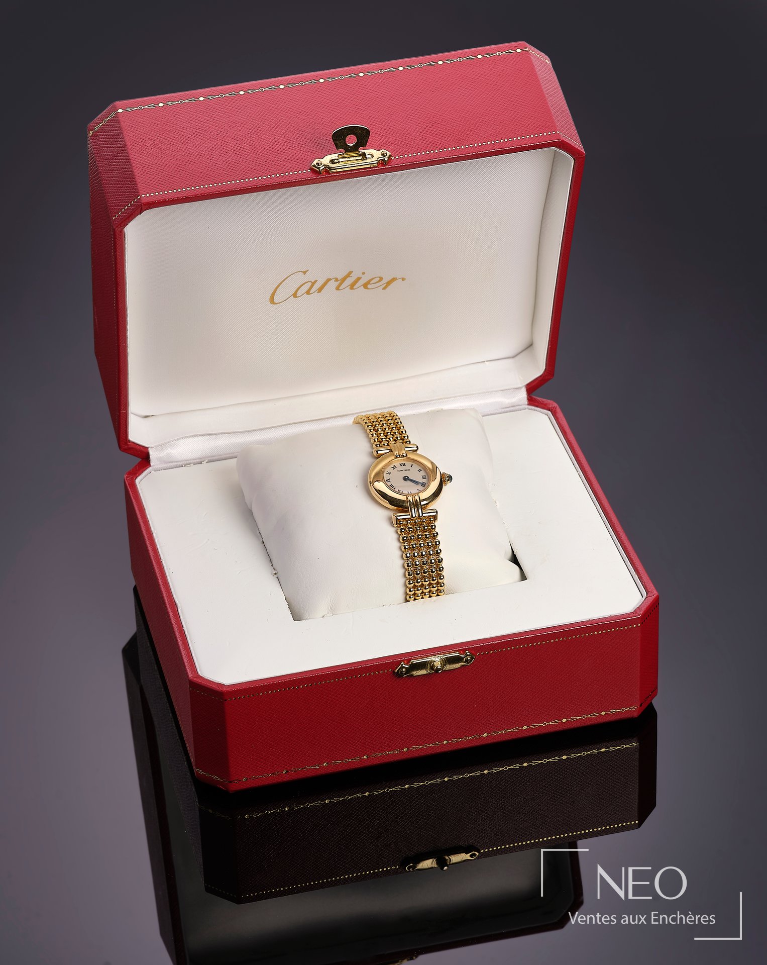 Montre Cartier Colisée en or jaune présentée dans son écrin rouge et blanc