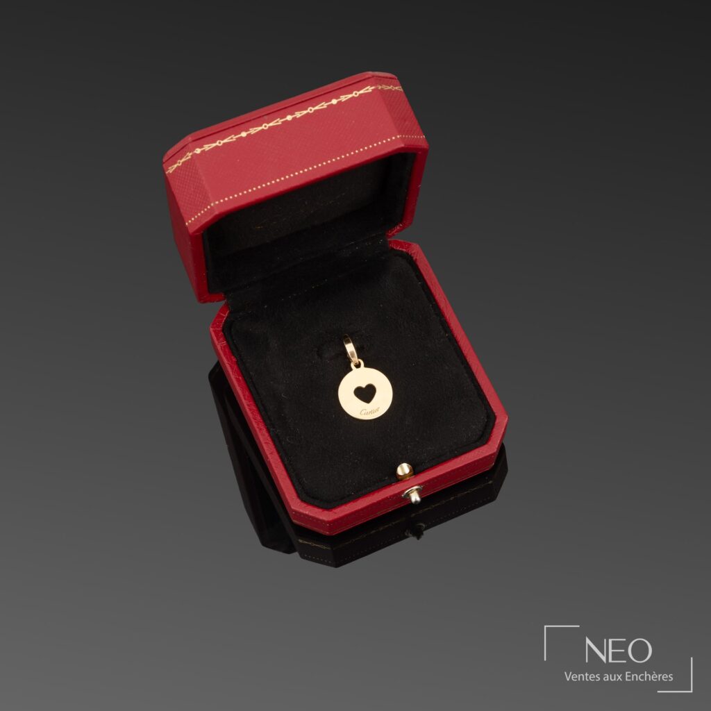 Pendentif Cartier en or jaune présenté dans son écrin rouge et noir