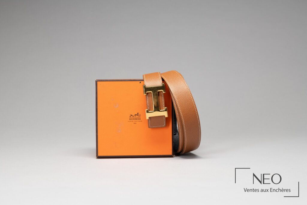 Ceinture Hermès réversible posée contre sa boîte orange