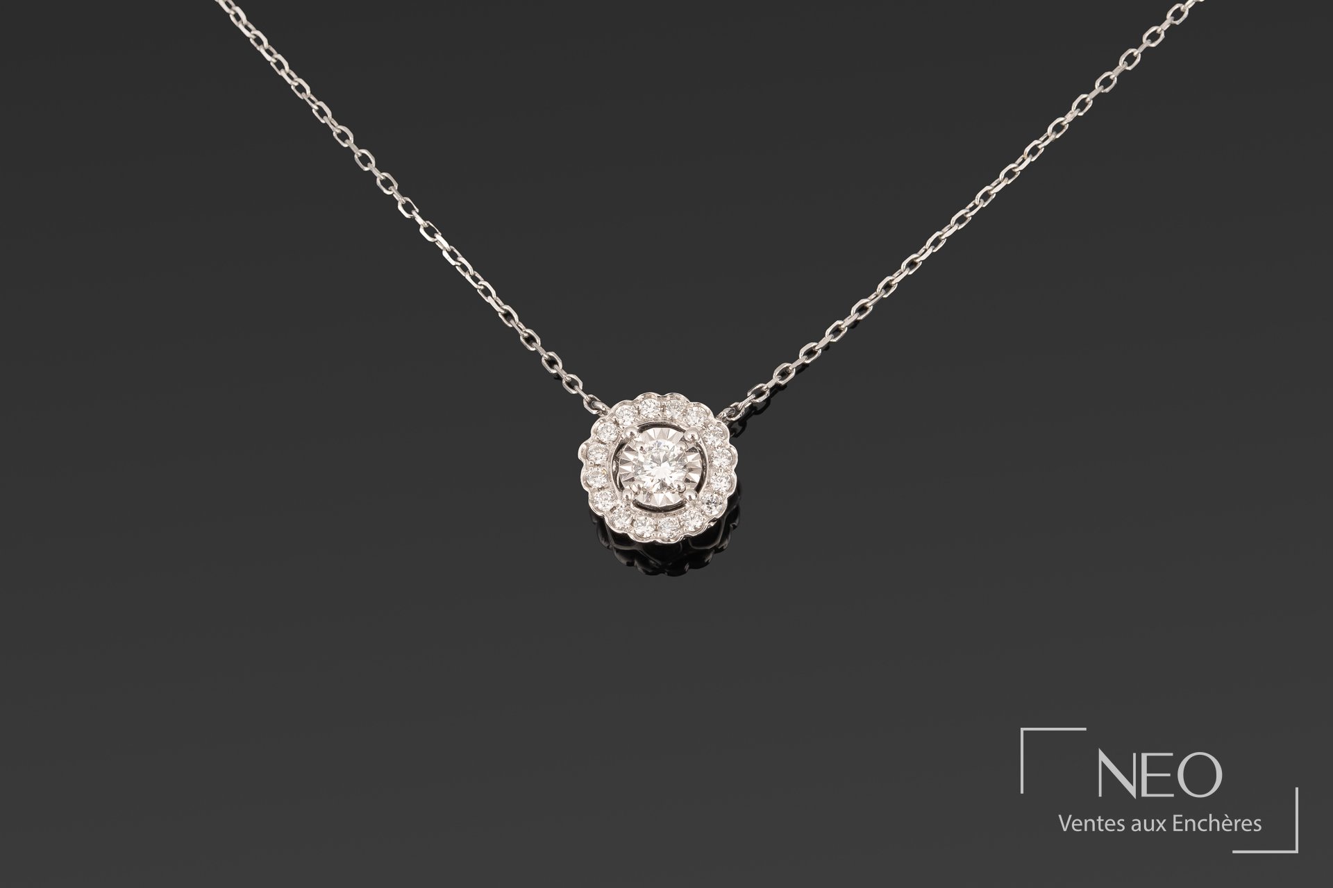 Chaîne de cou en or gris avec pendentif rond serti de diamants sur fond sombre