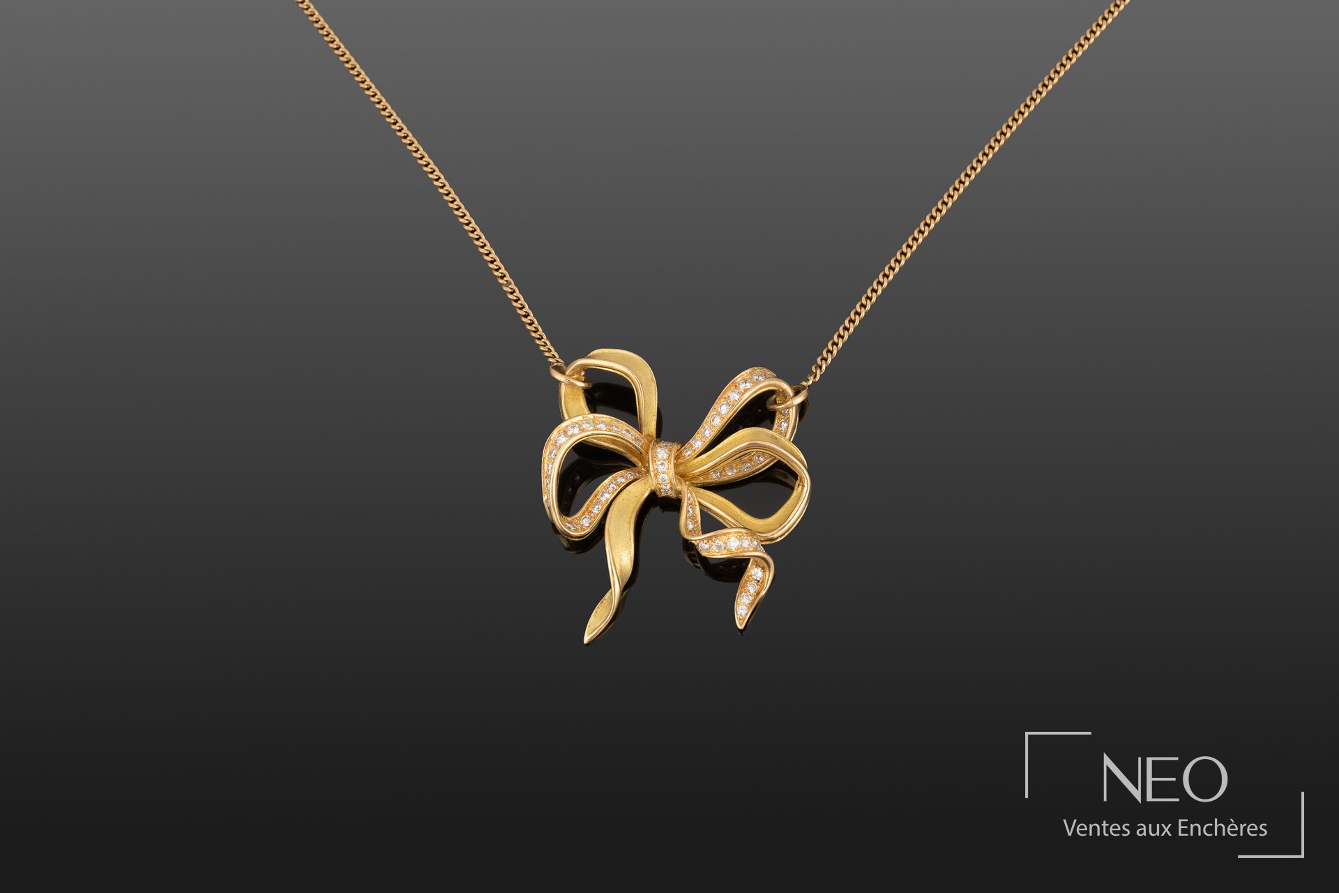 Chaîne de cou en or jaune avec pendentif nœud serti de petites pierres