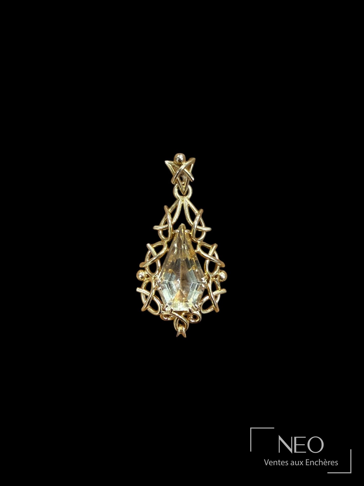 Pendentif en or jaune avec pierre taillée et monture ajourée sur fond noir