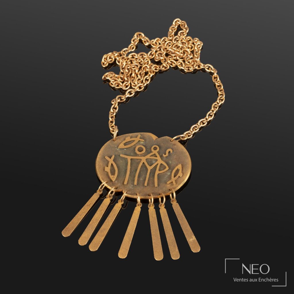 Chaîne de cou en or jaune avec pendentif oblong à décor stylisé de poissons