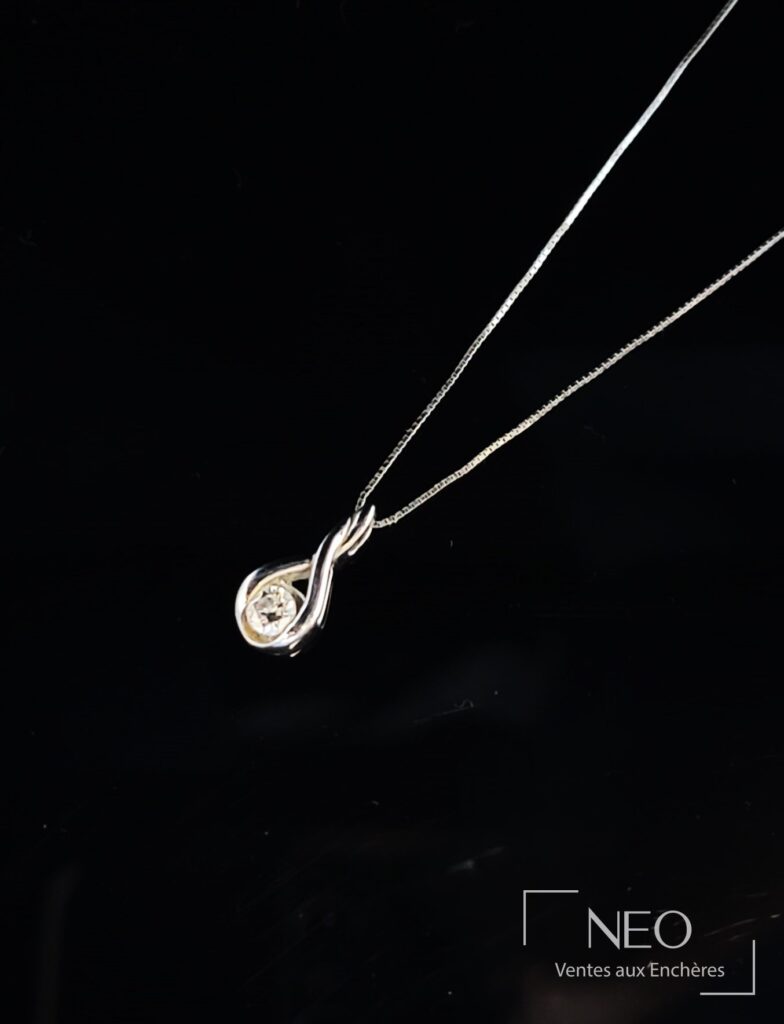 Chaîne de cou en or gris avec pendentif serti d’un diamant sur fond noir
