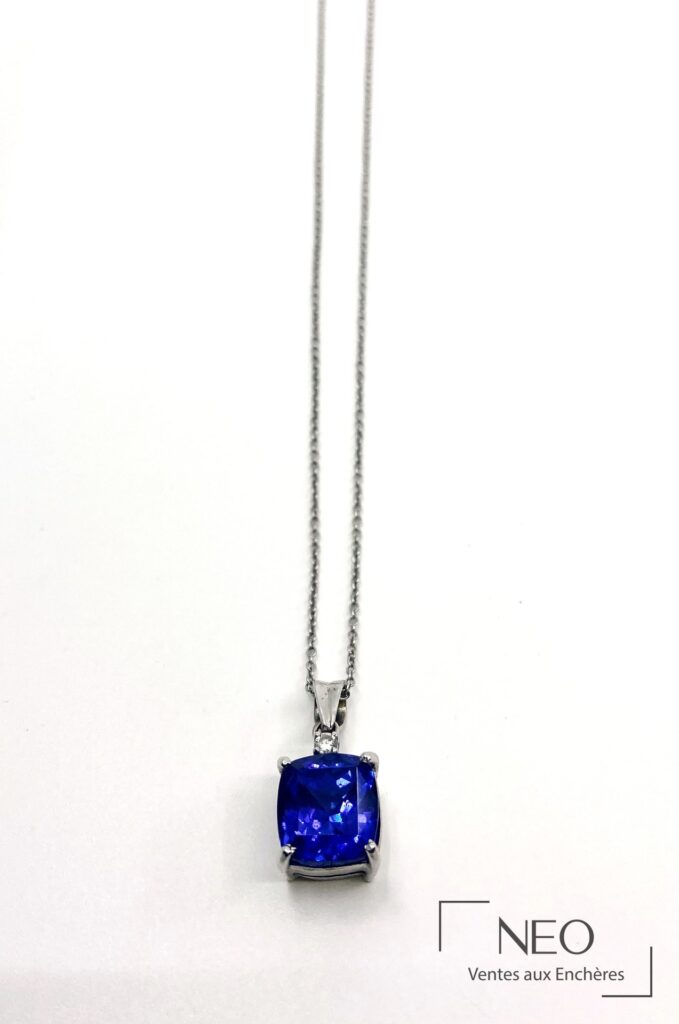 Chaîne de cou en or gris avec pendentif serti d'une tanzanite bleue et d'un petit diamant