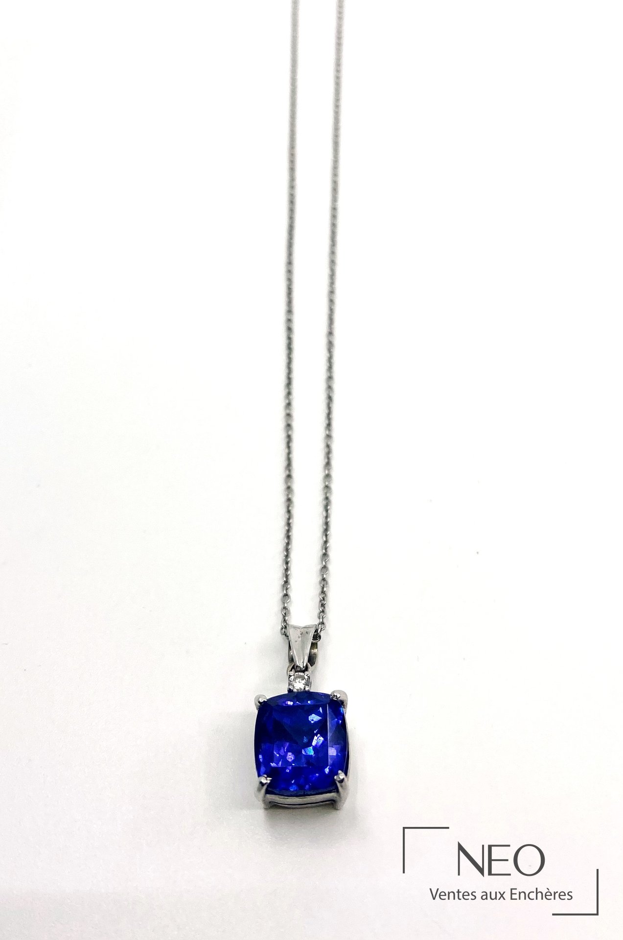 Chaîne de cou en or gris avec pendentif serti d'une tanzanite bleue et d'un petit diamant