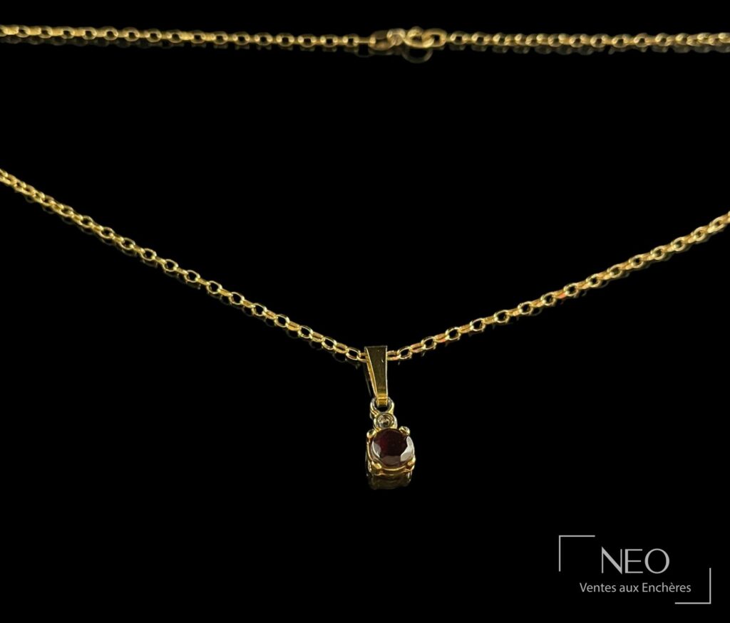 Chaîne en or jaune avec pendentif serti d'une pierre sombre