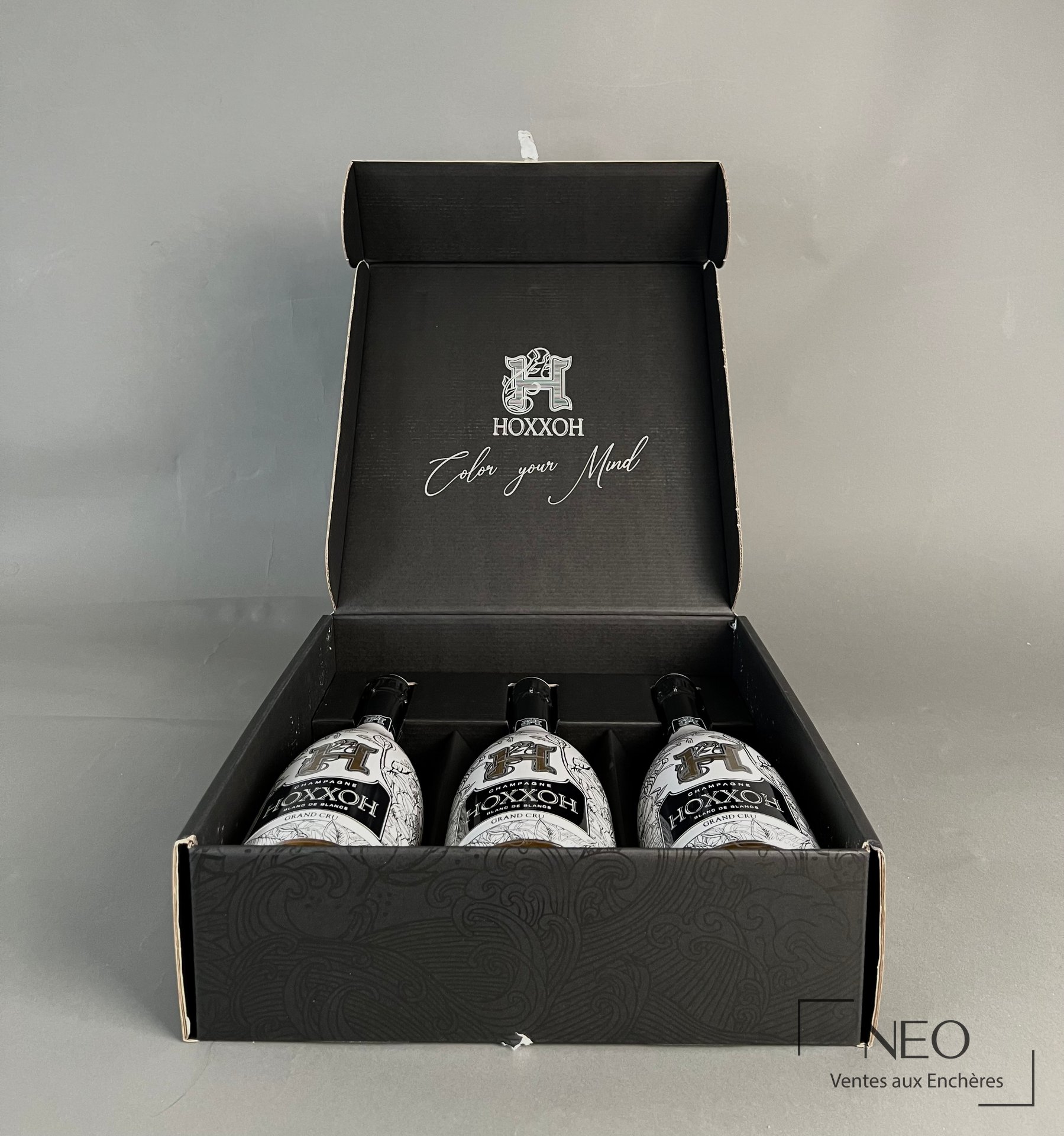 Coffret ouvert contenant trois bouteilles de champagne HOXXOH