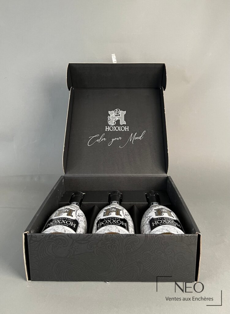Coffret ouvert avec trois bouteilles de champagne HOXXOH rangées à l'intérieur.