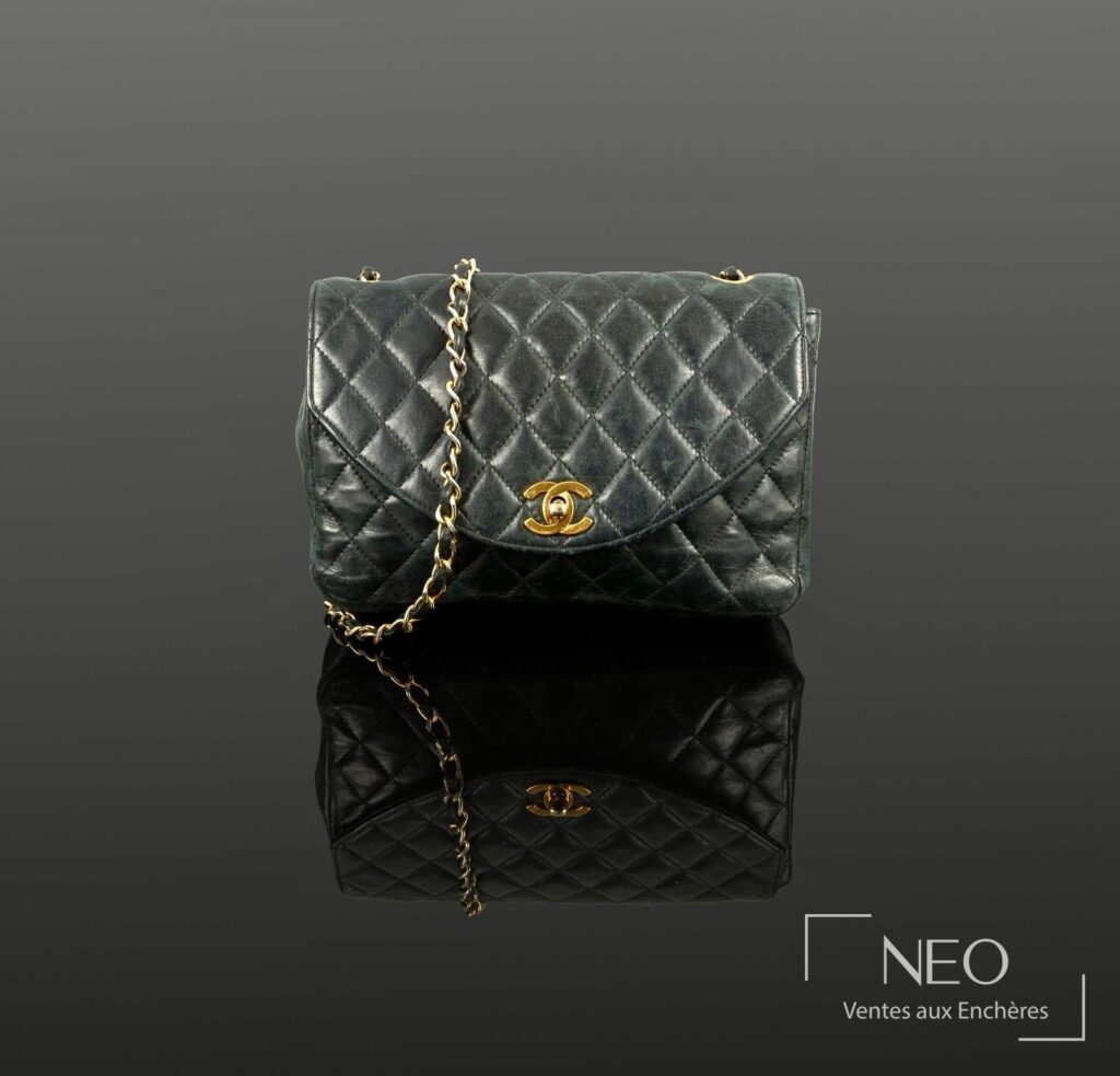 Sac à rabat CHANEL en agneau matelassé bleu marine avec chaîne et logo doré