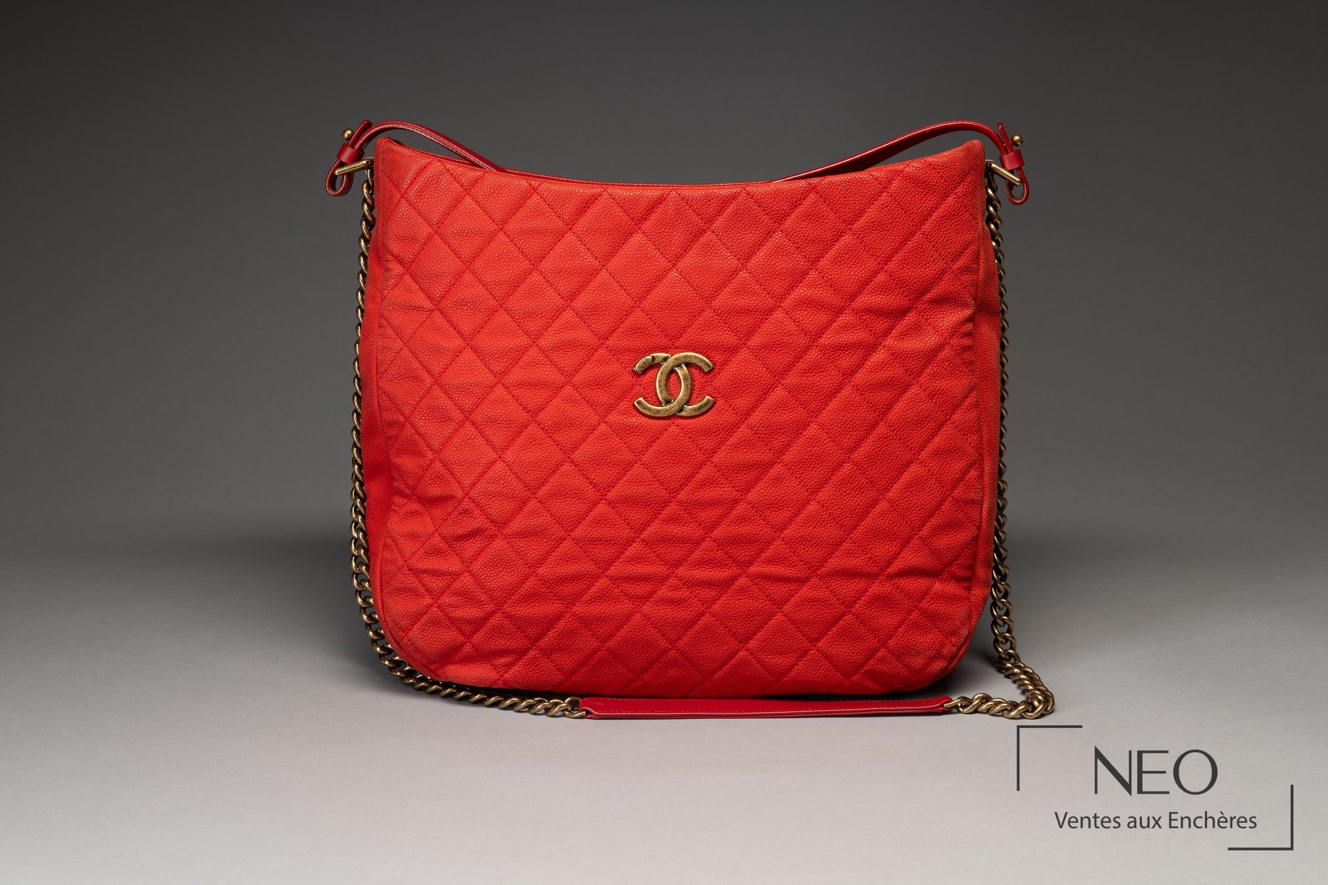 Sac CHANEL rouge corail vu de face avec logo CC doré et bandoulière