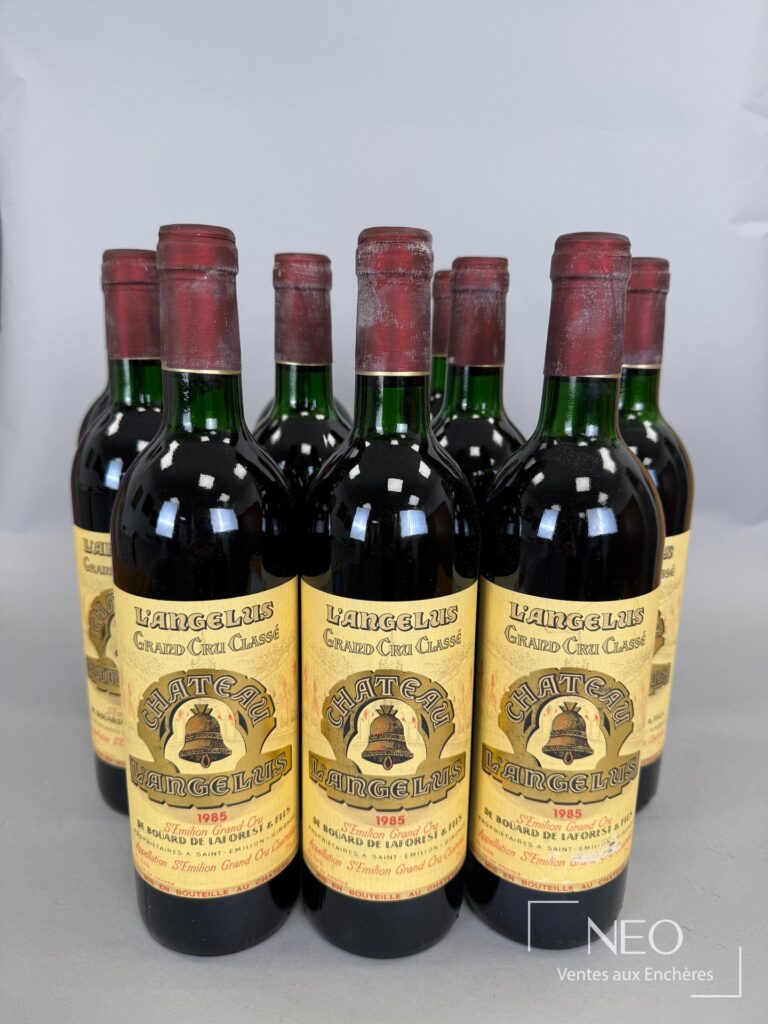 Douze bouteilles de Château L’Angélus 1985 présentées de face avec leurs étiquettes